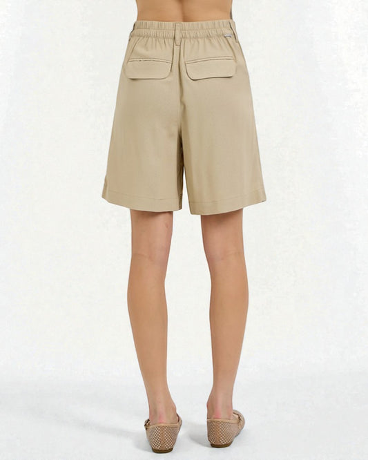 Beige shorts worn by a person on a white background