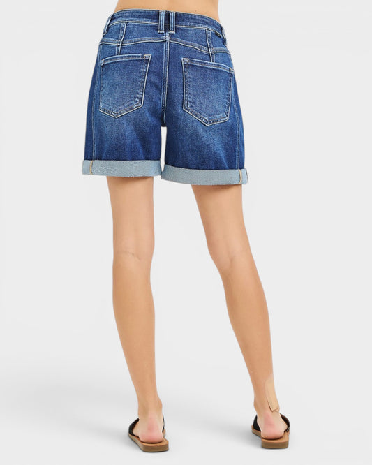 Blue denim shorts worn by a person on a white background