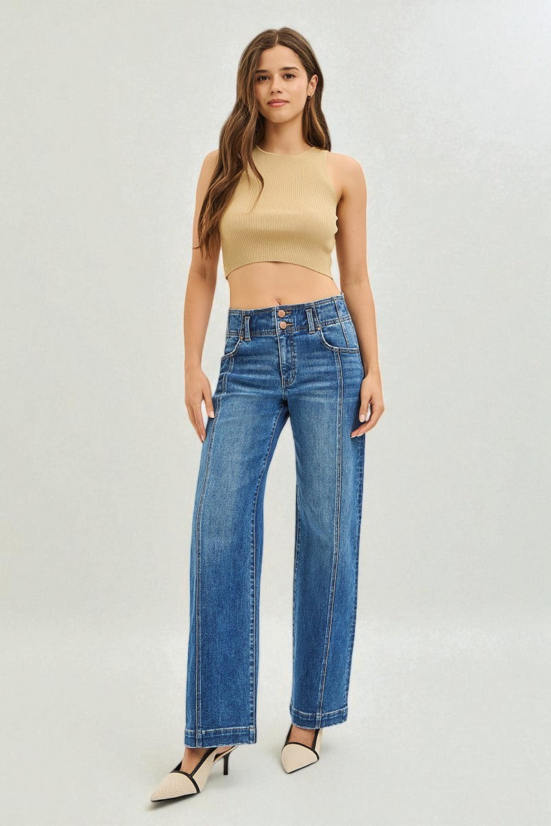 Woman wearing a beige top and blue jeans on a white background