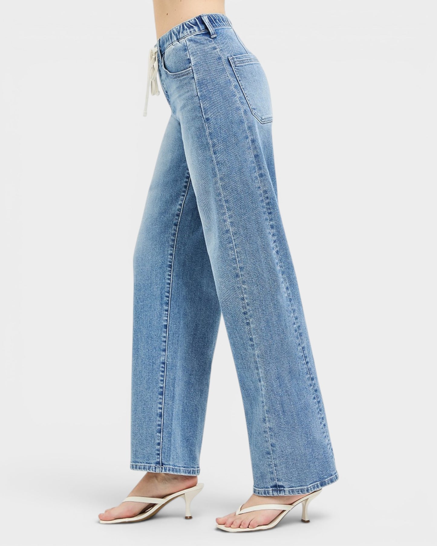 Light blue jeans worn by a person on a white background