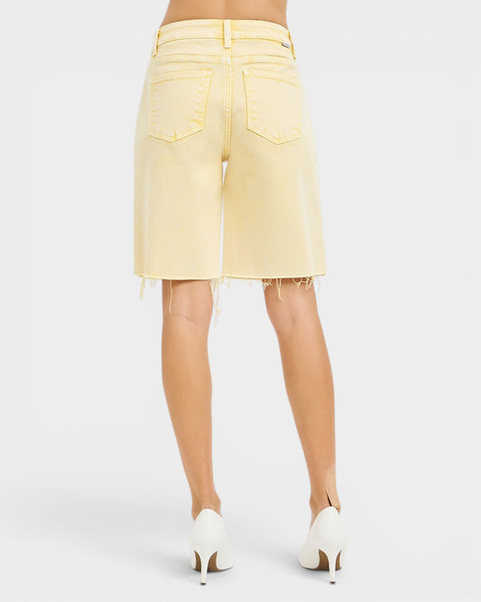 Light yellow denim shorts worn by a person on a white background