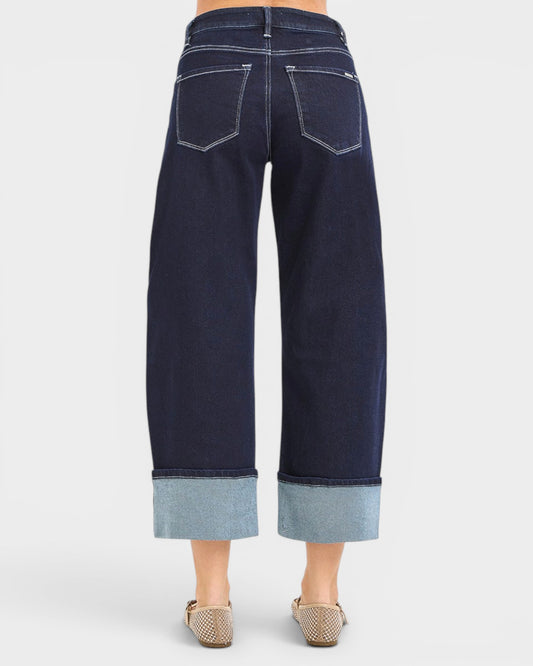 Navy blue jeans with cuffed hem on a white background