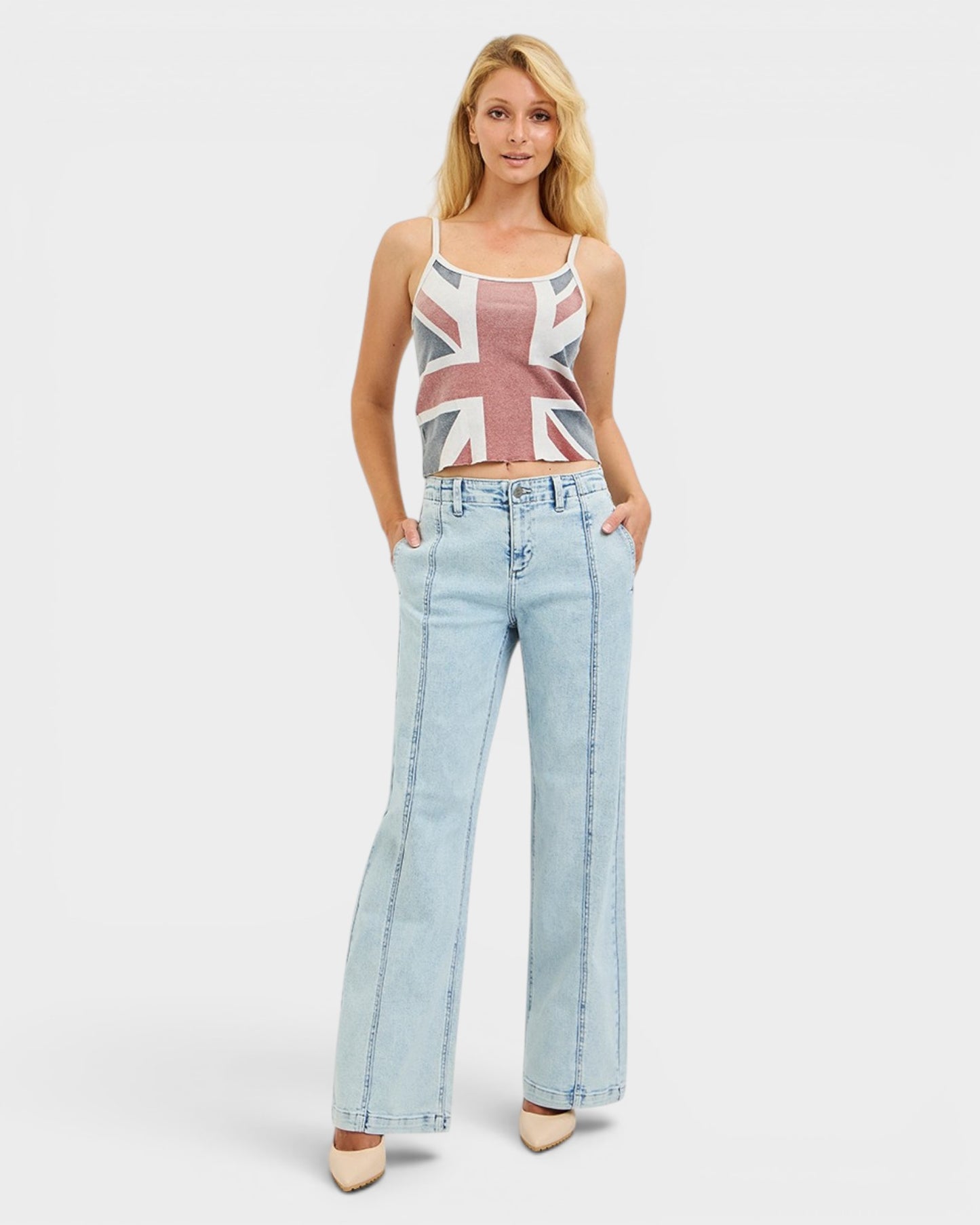 Woman wearing a Union Jack top and light blue jeans on a white background