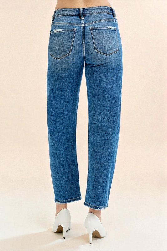 Blue jeans worn by a person on a beige background