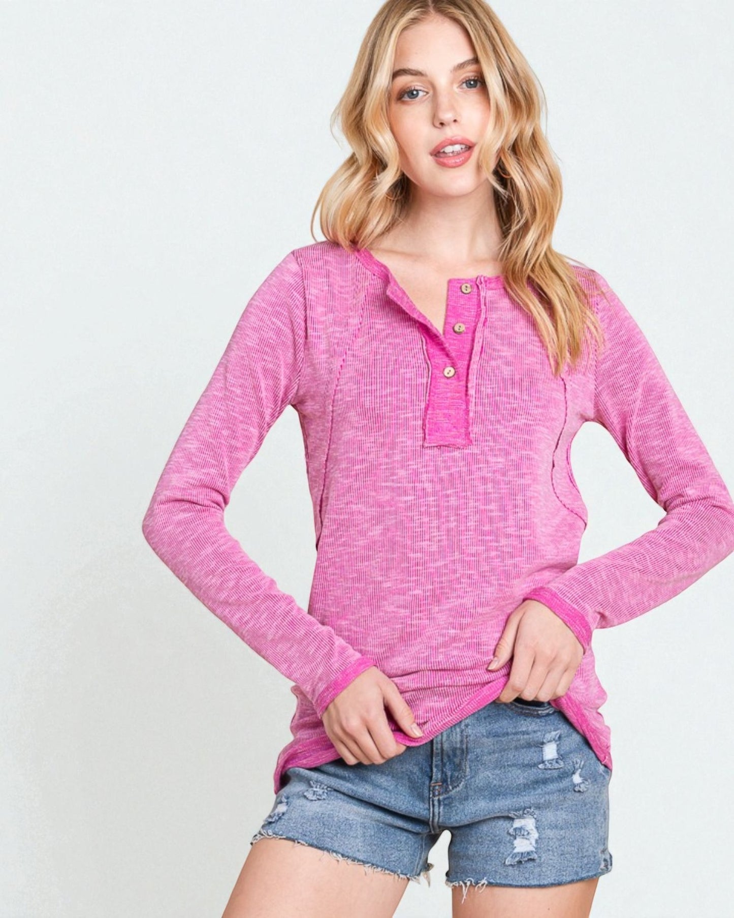 Woman wearing a pink long-sleeve top with a white background