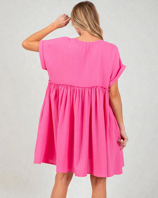 Woman wearing a pink dress against a plain background