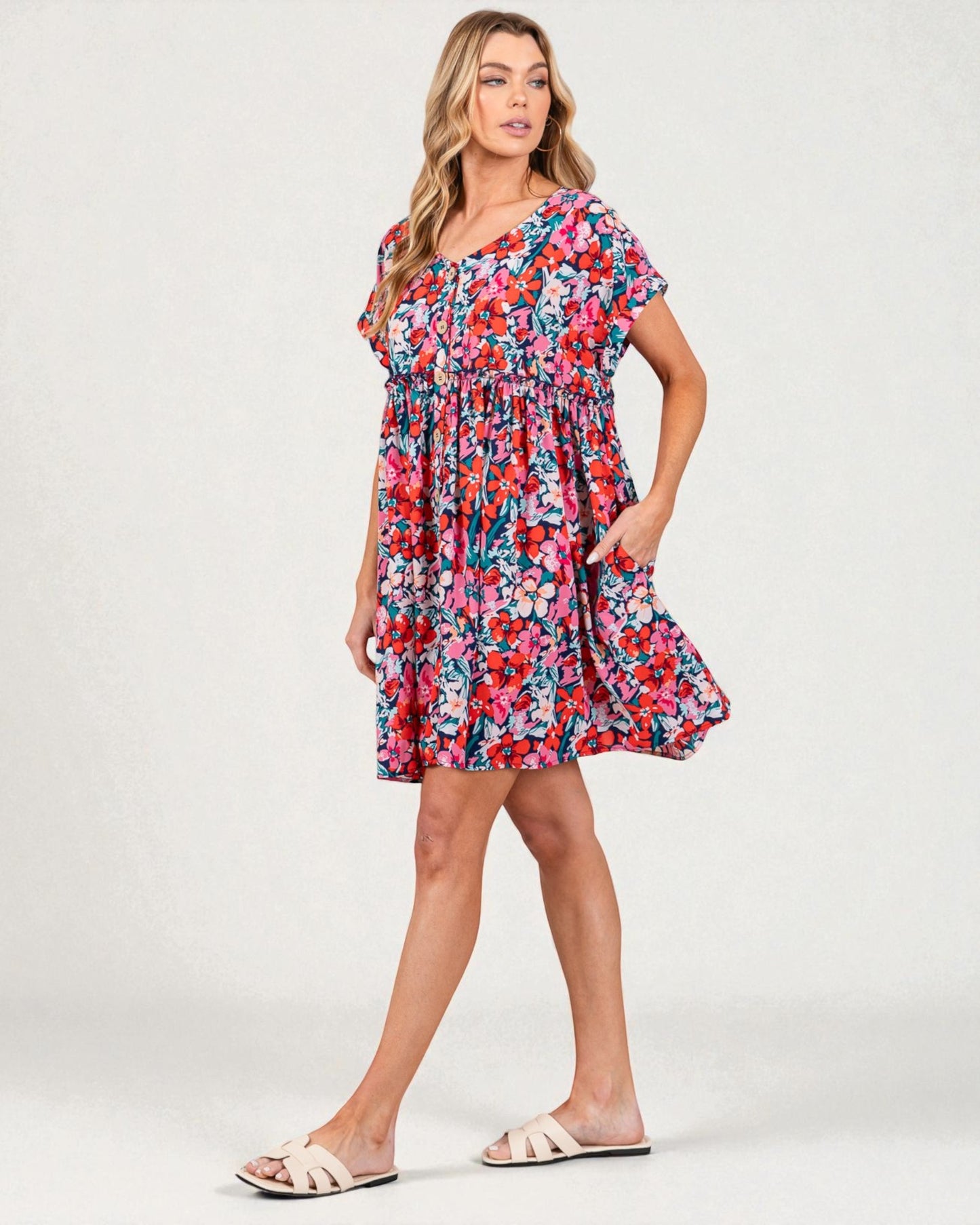 Woman wearing a colorful floral dress on a white background