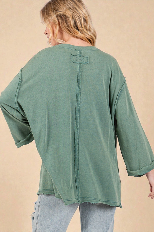 Green oversized shirt worn by a person on a beige background