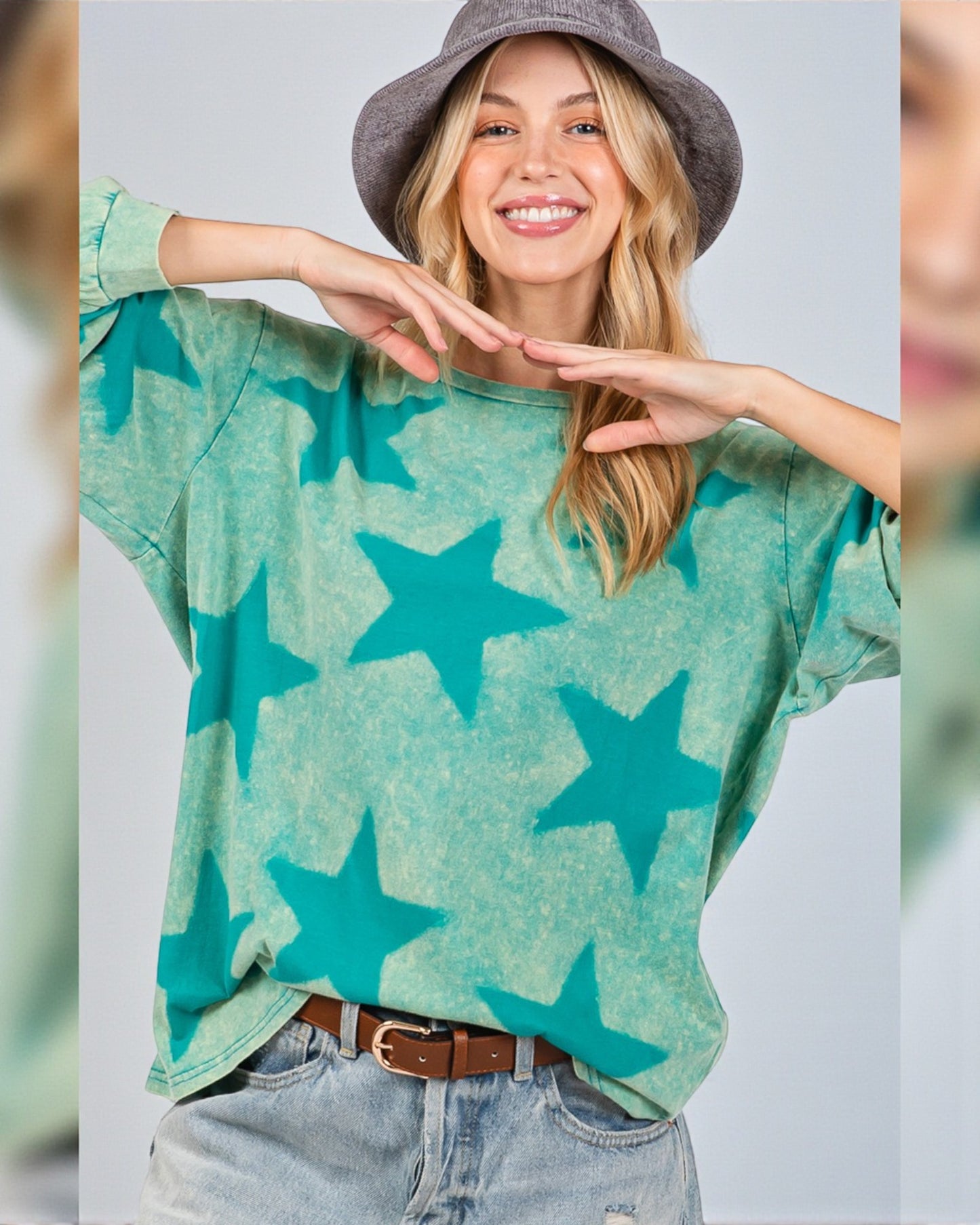 Person wearing a green sweater with blue star patterns, posing against a plain background
