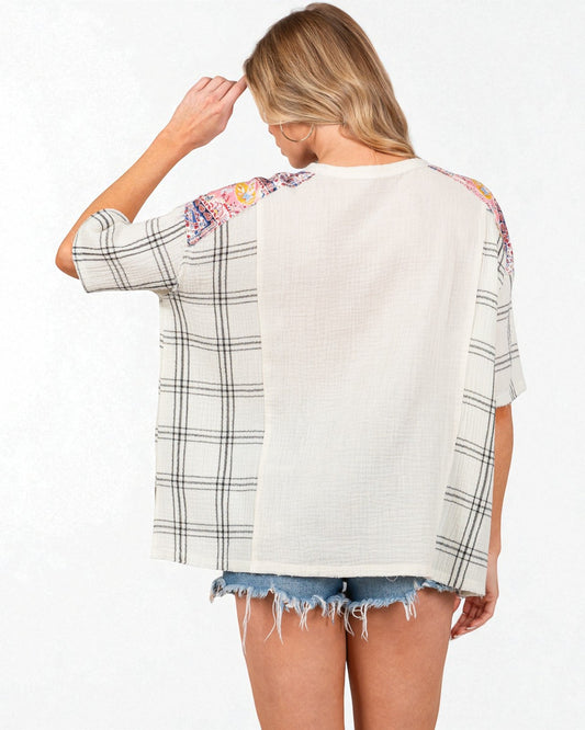 Woman wearing a white and plaid shirt with floral sleeves on a white background