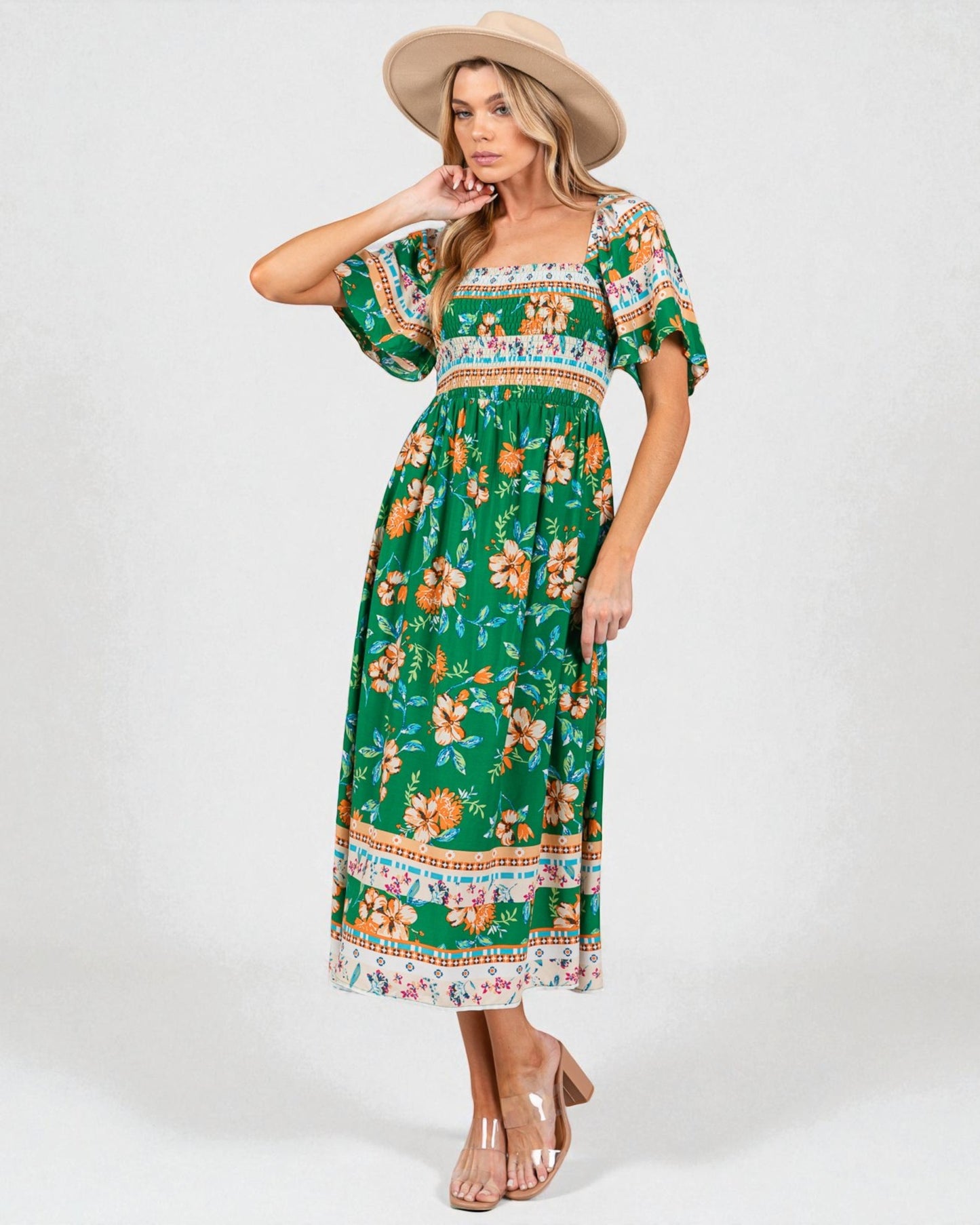 Woman wearing a green floral dress with a white background