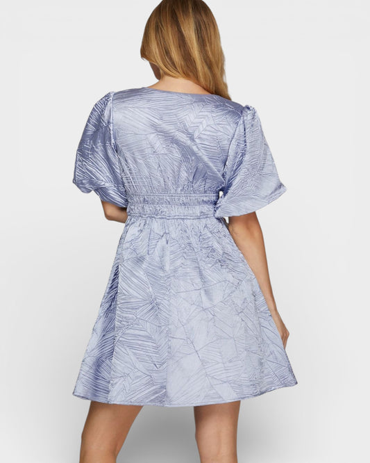 Woman wearing a blue patterned dress on a white background