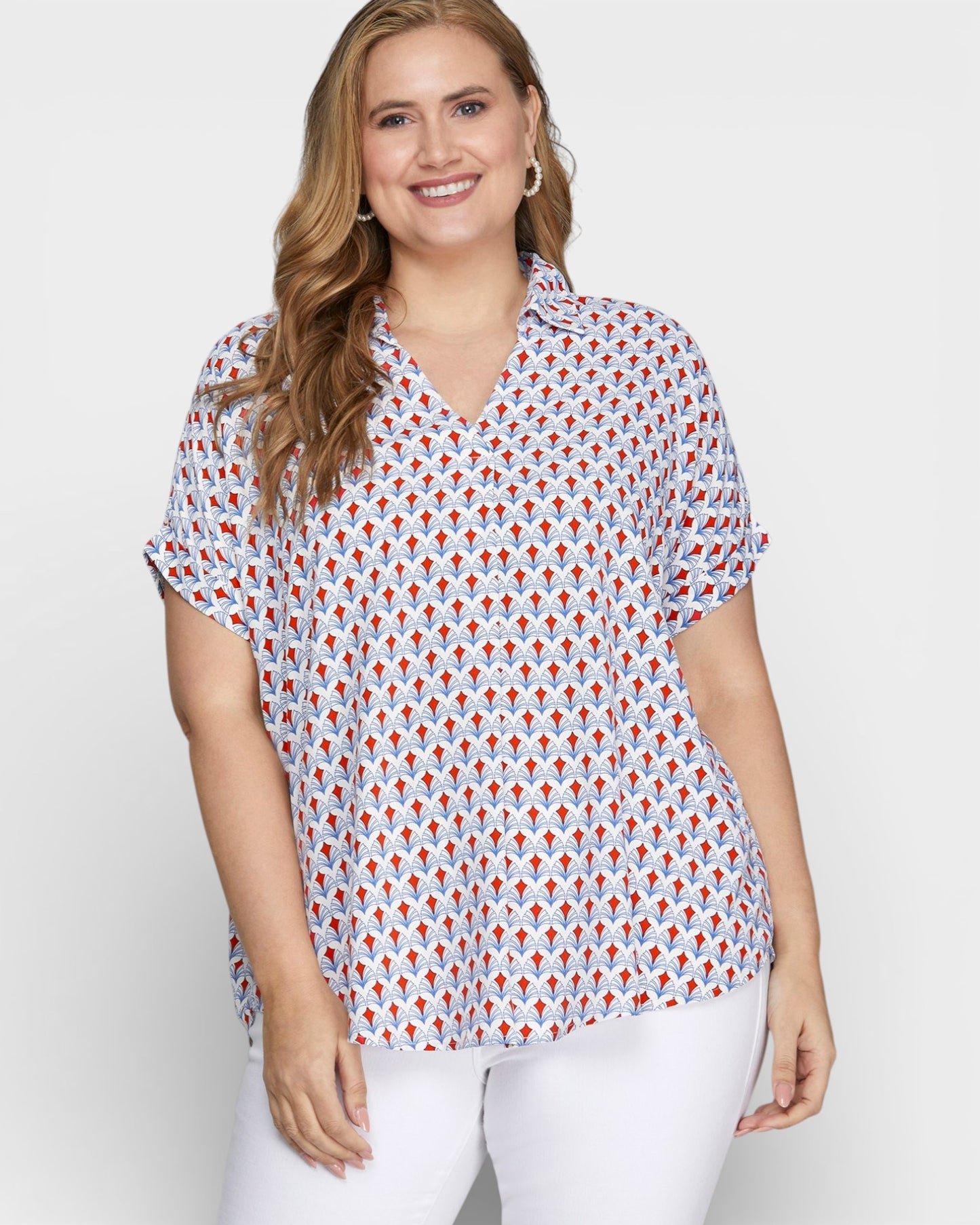 Woman wearing a patterned blouse with a plain background