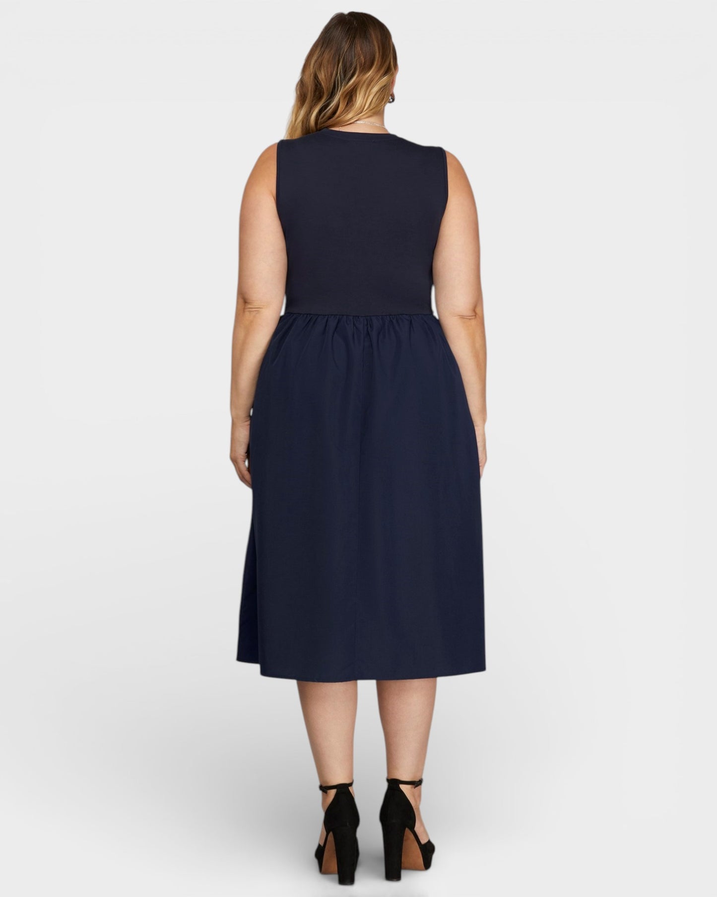 Woman wearing a navy blue dress on a white background