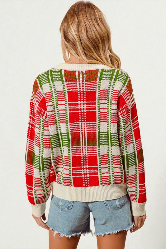 Person wearing a red and green plaid sweater with denim shorts on a white background