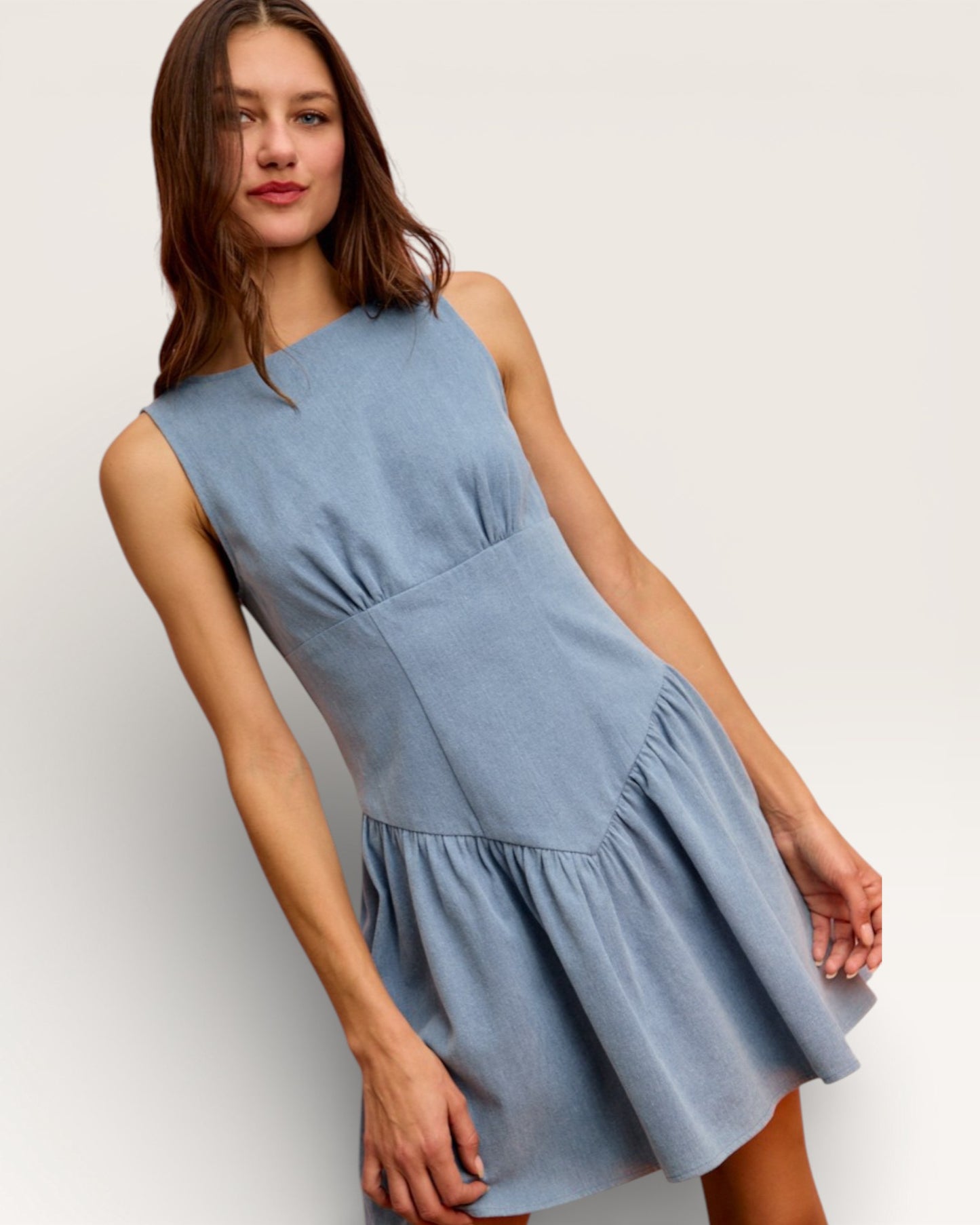 Woman wearing a light blue dress against a plain background