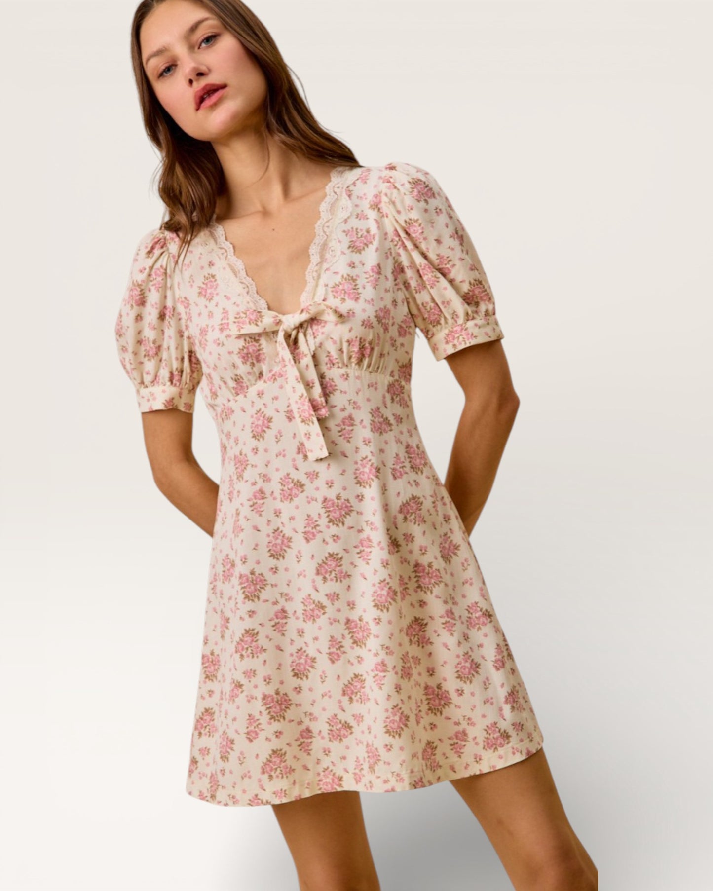 Woman wearing a floral dress against a plain background