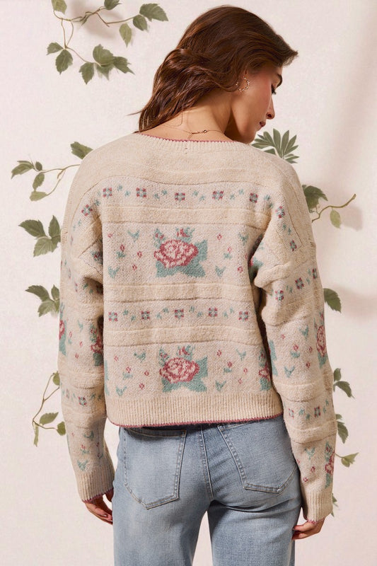 Woman wearing a floral-patterned sweater with a neutral background
