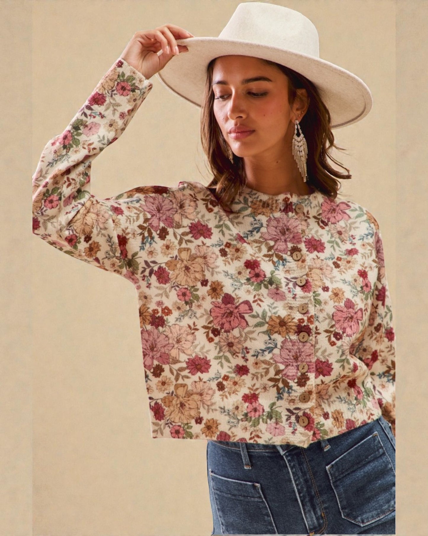 Woman wearing a floral blouse and white hat against a beige background