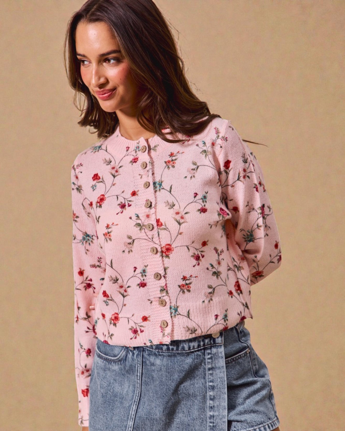 Woman wearing a pink floral blouse against a beige background