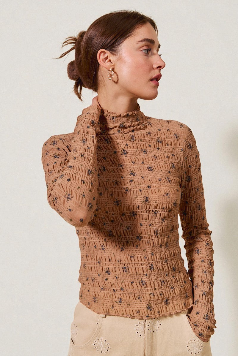 Woman wearing a brown patterned sweater against a white background