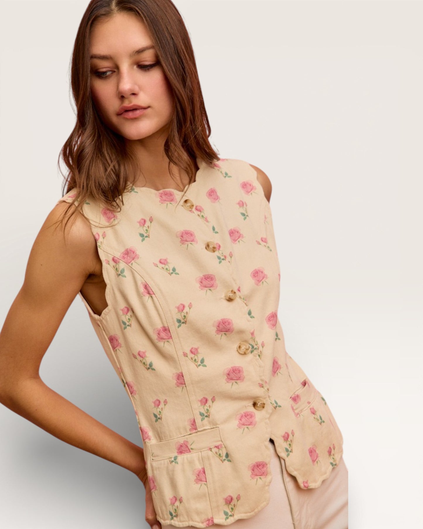Woman wearing a beige floral dress against a plain background