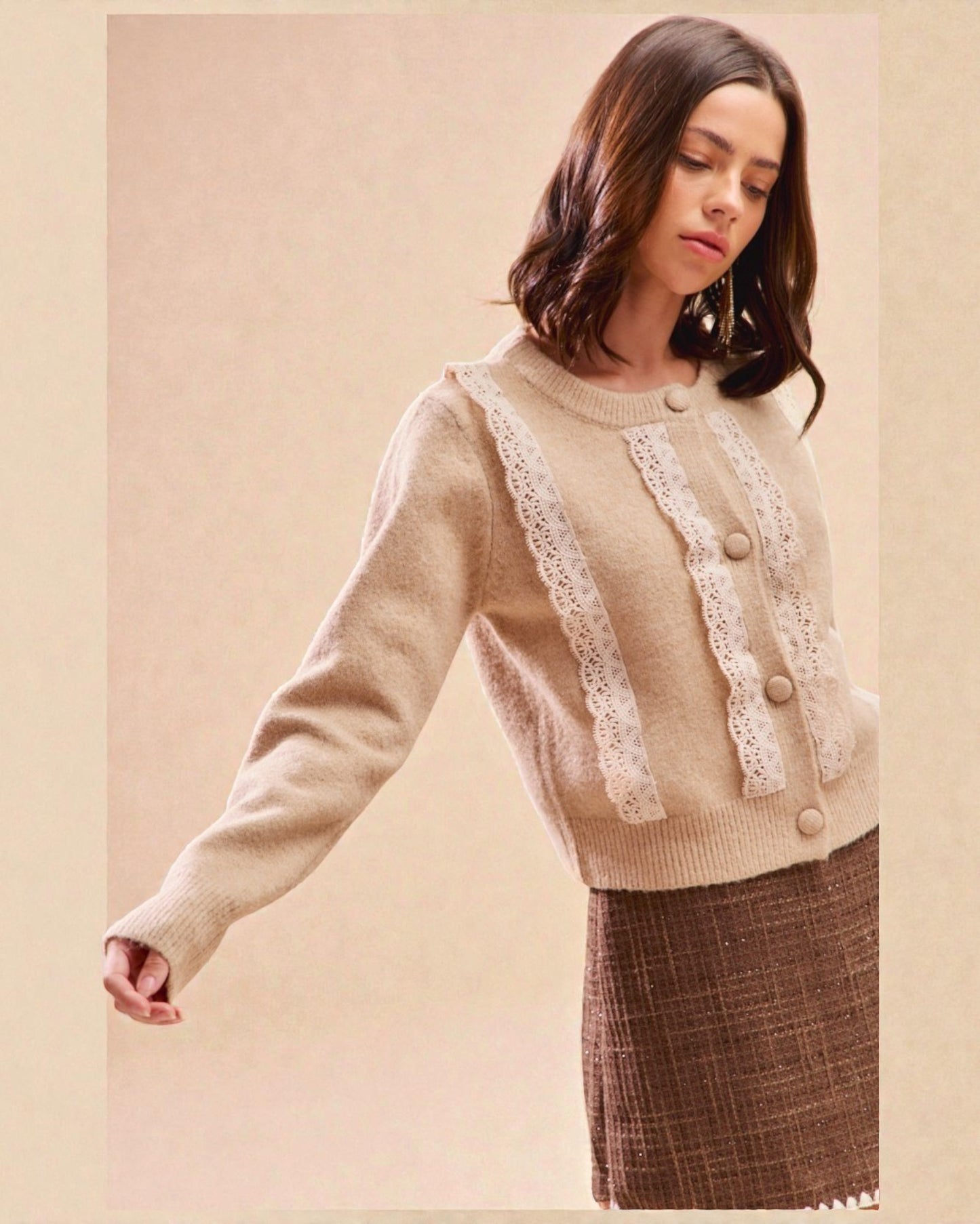 Woman wearing a beige sweater with lace details on a beige background
