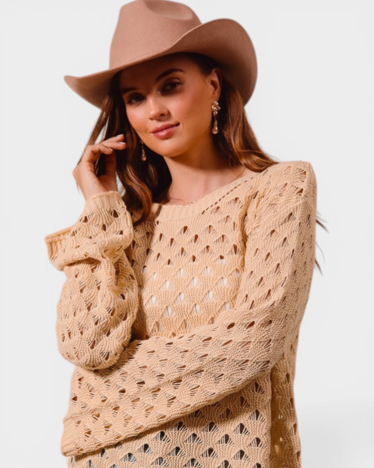 Woman wearing a beige knitted sweater and hat on a light background