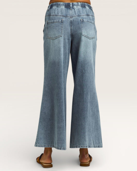 Blue jeans being worn on a white background