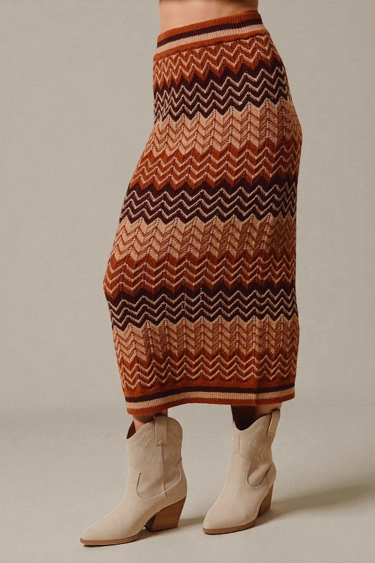 Person wearing a patterned skirt and white boots on a neutral background