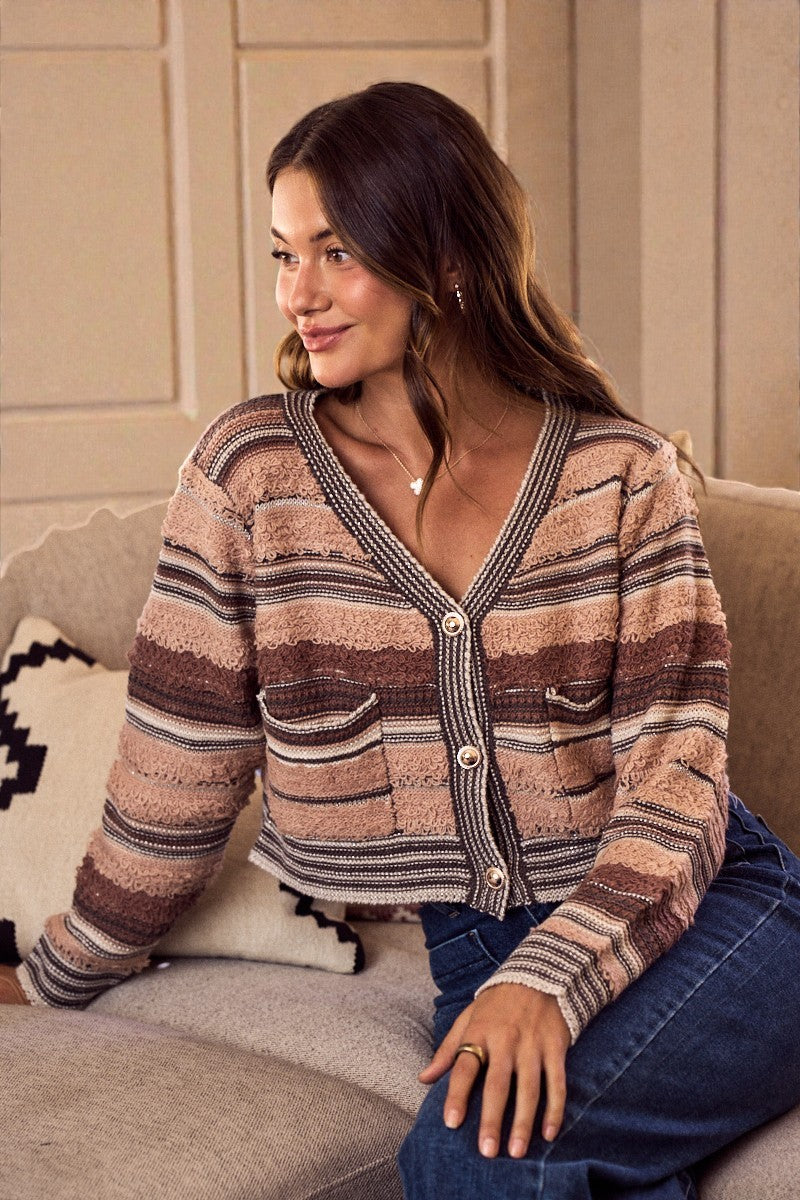 Woman wearing a striped cardigan sitting on a couch.
