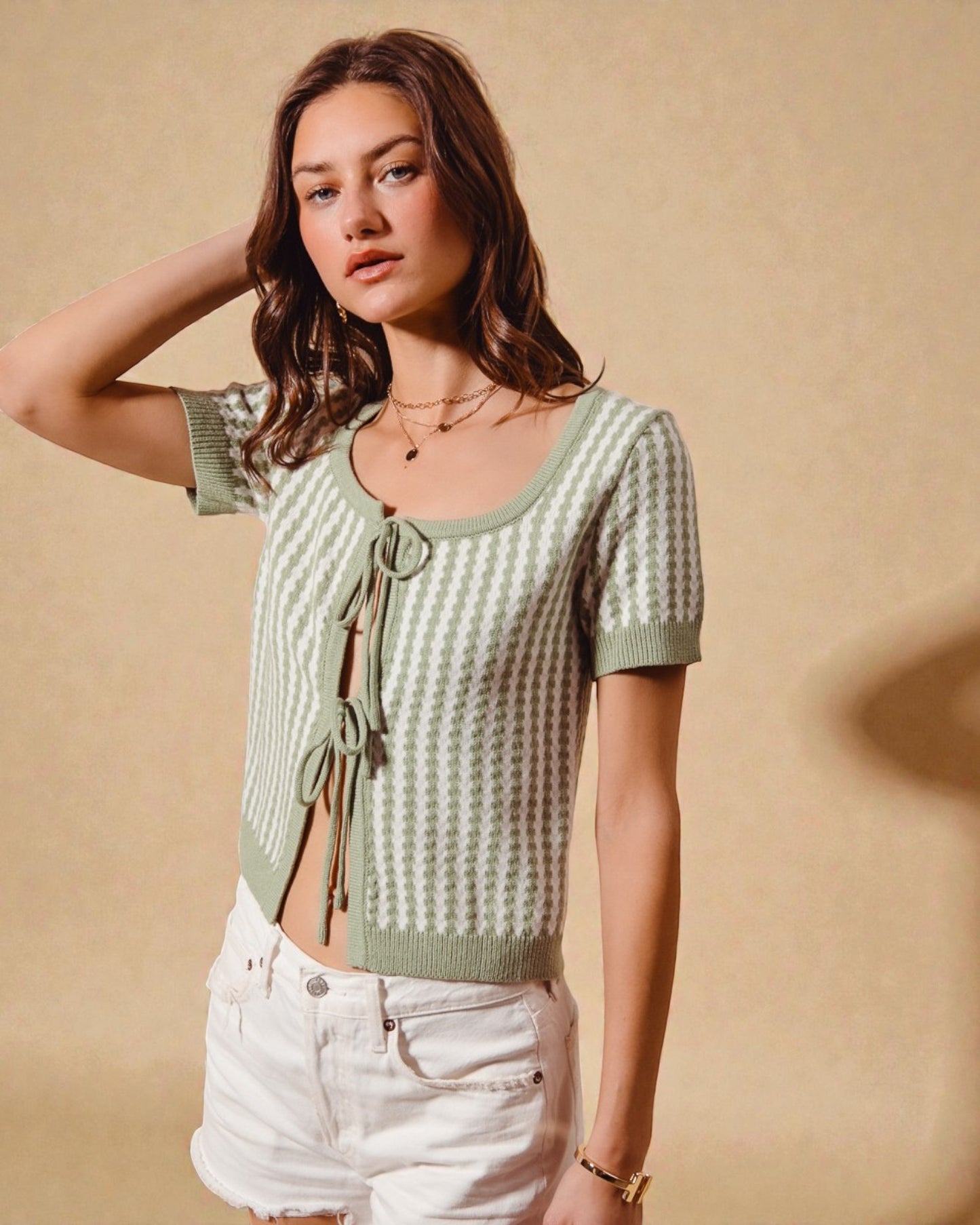 Woman wearing a green patterned top with a beige background