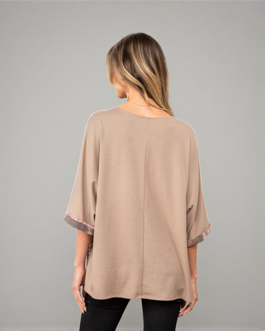 Woman wearing a beige blouse against a gray background