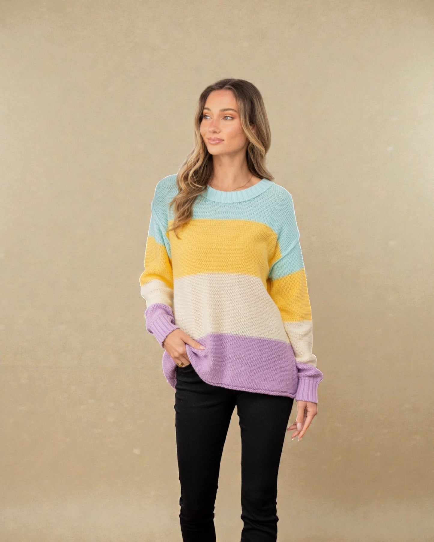 Woman wearing a colorful striped sweater against a beige background
