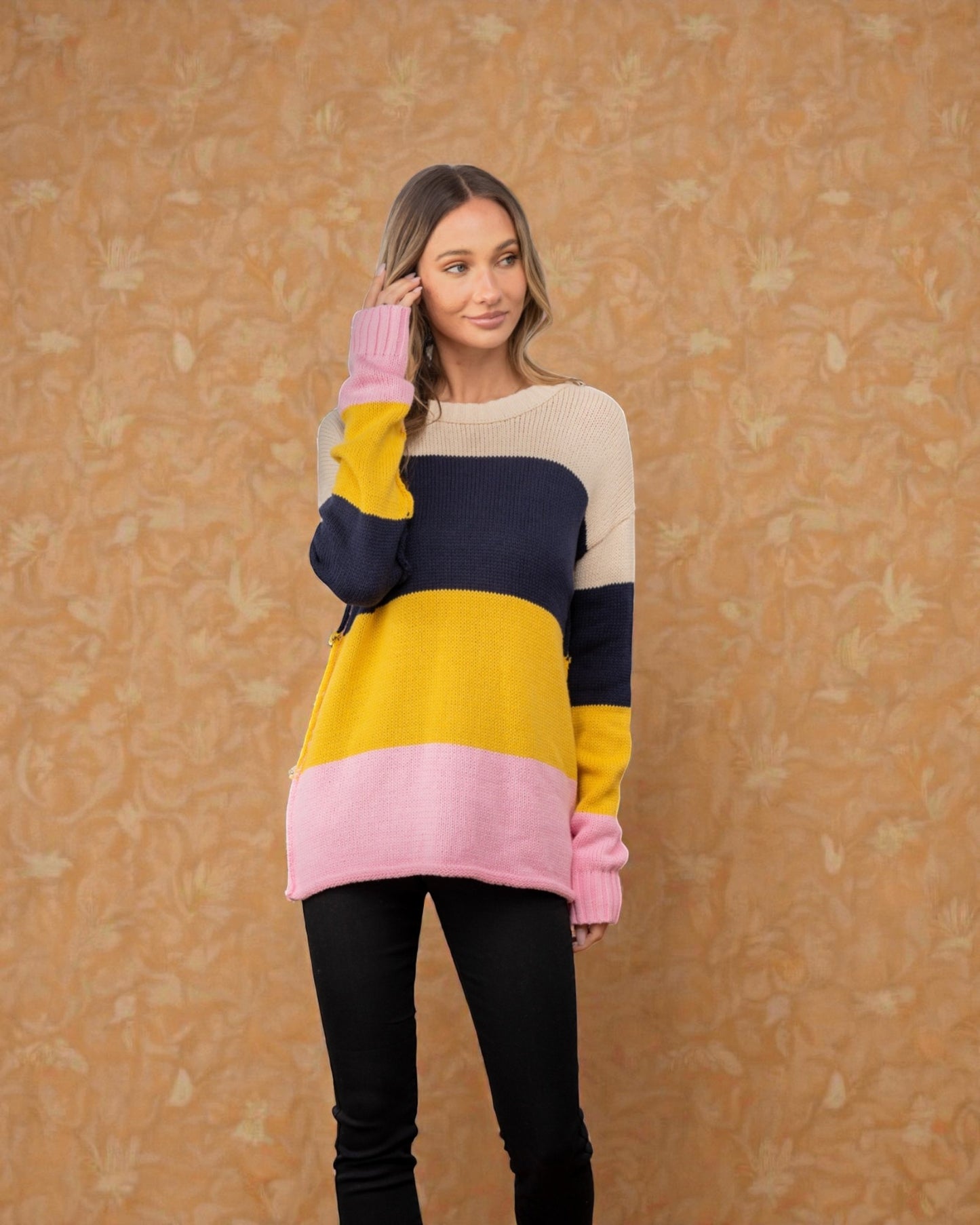 Woman wearing a colorful sweater with a patterned background