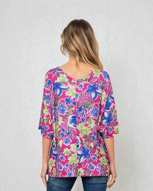 Woman wearing a colorful floral blouse against a white background