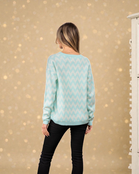 Person wearing a light blue sweater with a subtle pattern against a beige background