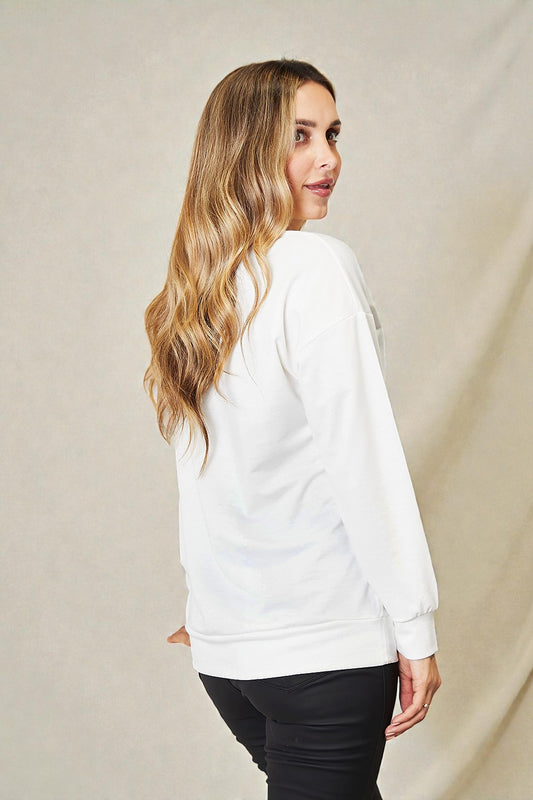 Woman wearing a white sweatshirt against a beige background