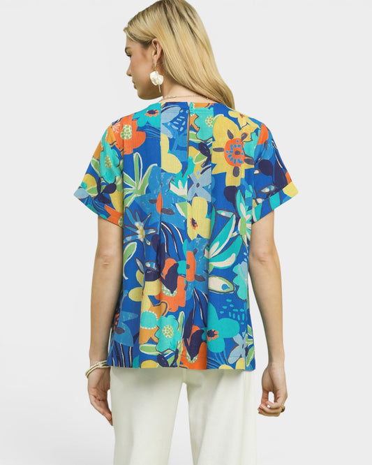 Woman wearing a colorful floral-patterned top on a white background