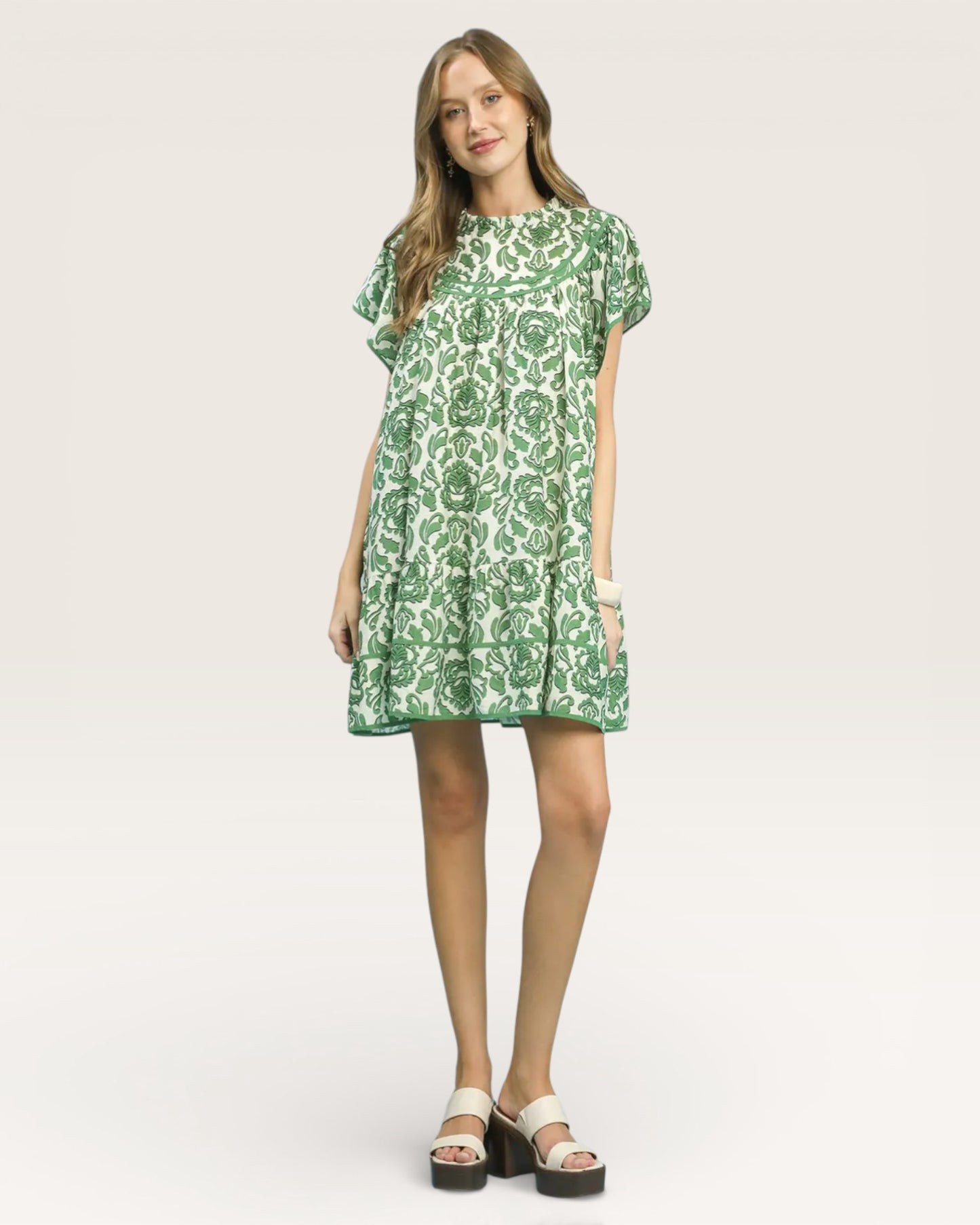 Woman wearing a green floral dress on a white background
