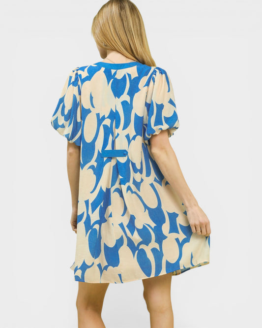 Woman wearing a blue and beige patterned dress on a white background