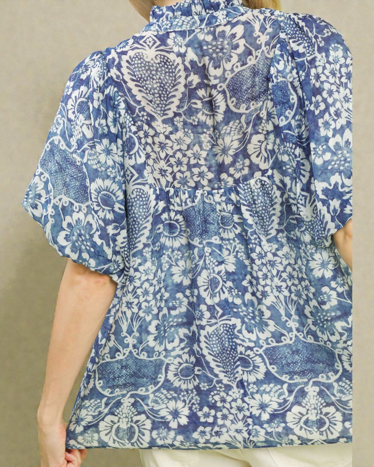 Blue and white floral patterned shirt on a beige background