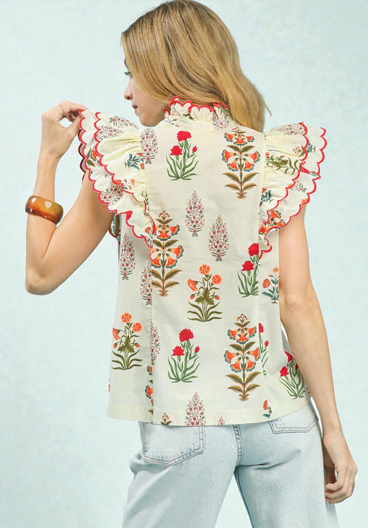 Woman wearing a floral blouse with ruffled sleeves on a light blue background