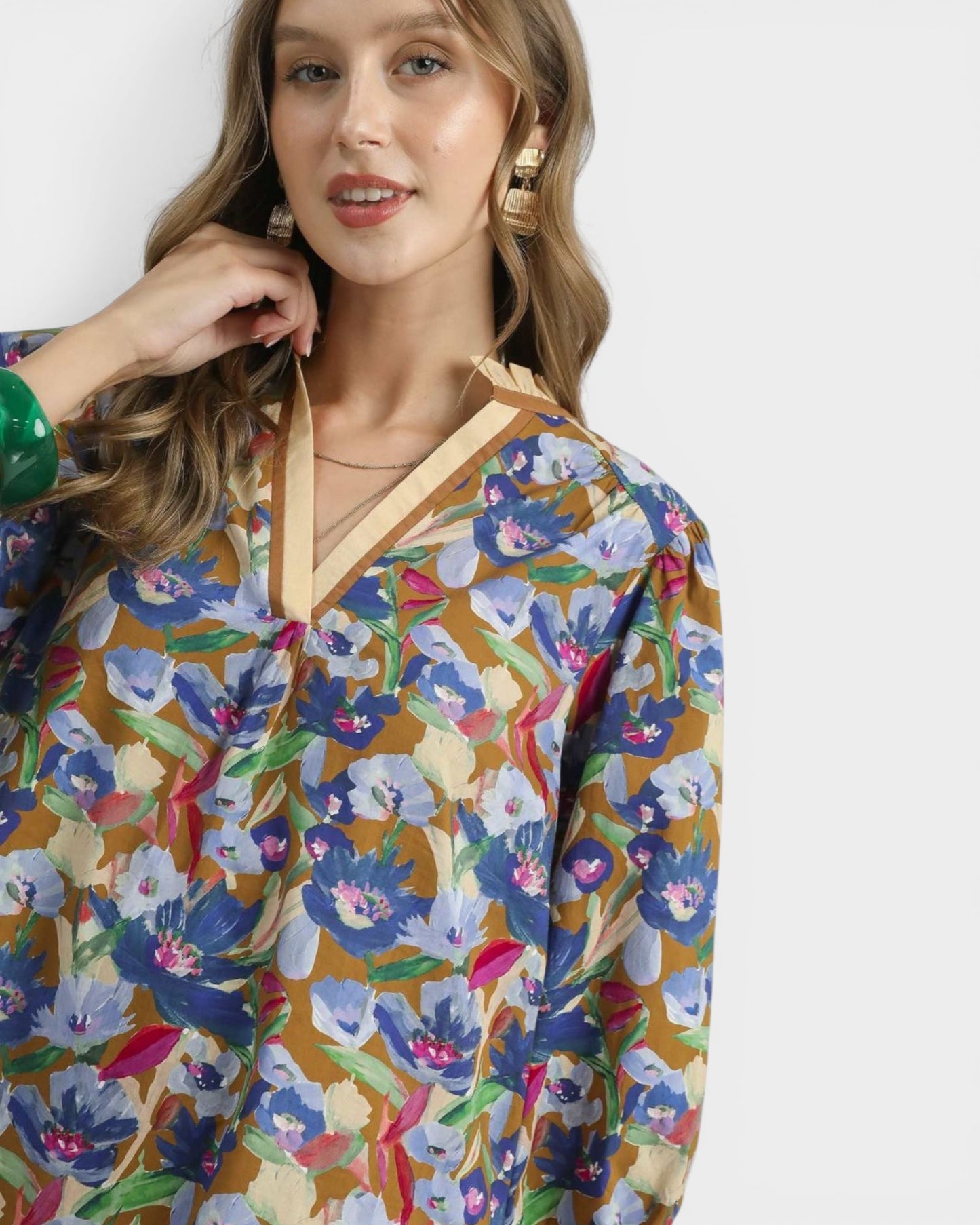 Woman wearing a colorful floral blouse with a plain background