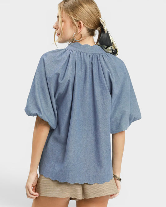 Woman wearing a blue blouse with a plain background