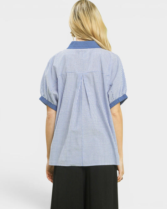 Person wearing a blue and white striped shirt on a white background
