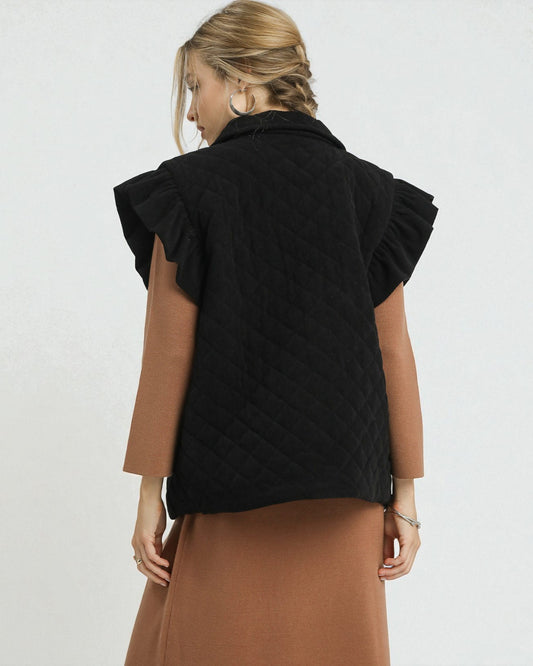 Woman wearing a black quilted vest over a brown dress on a white background