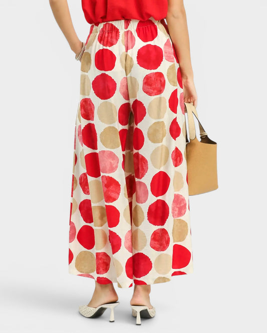 Person wearing a red and beige polka dot skirt on a white background