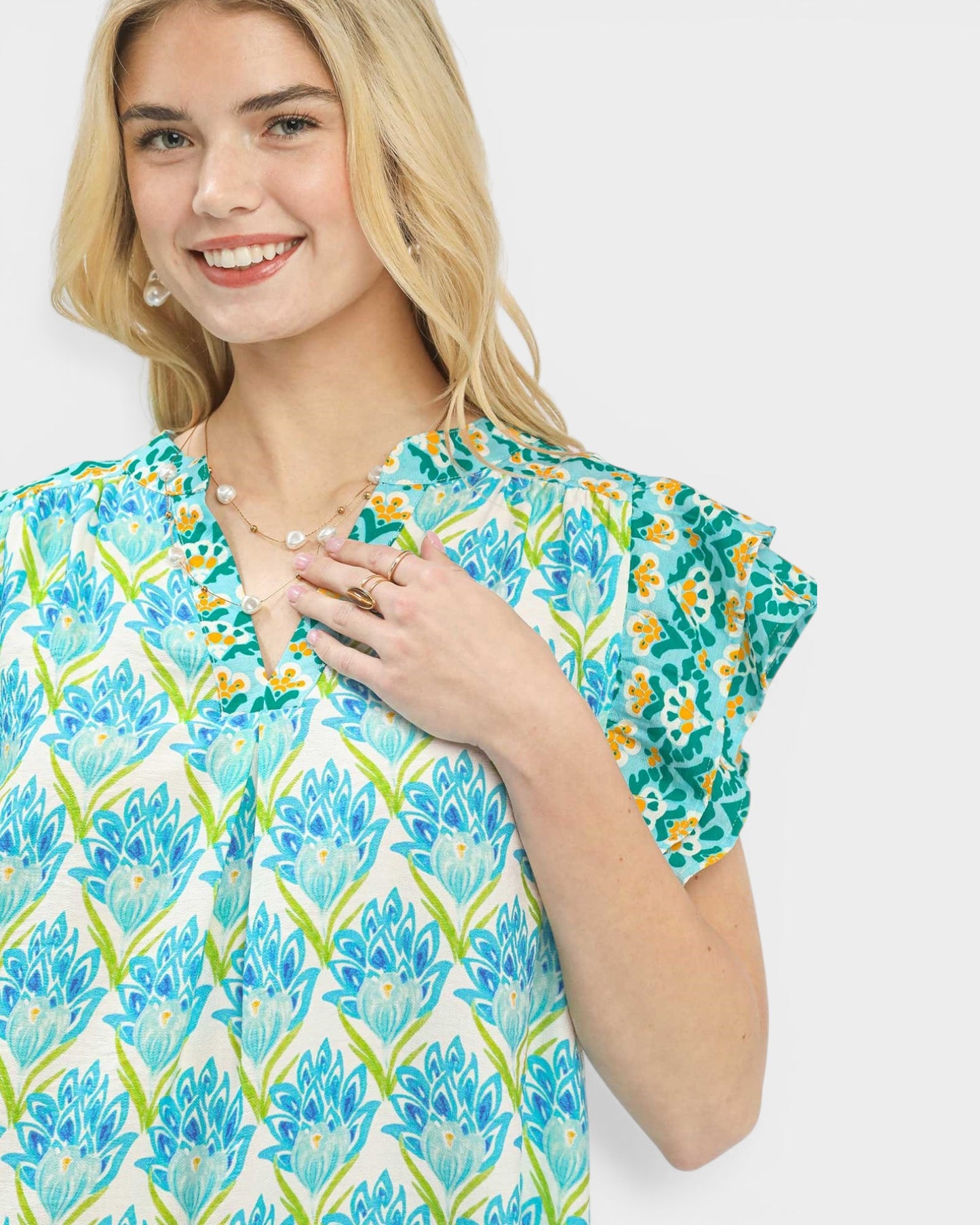 Woman wearing a floral patterned blouse on a white background