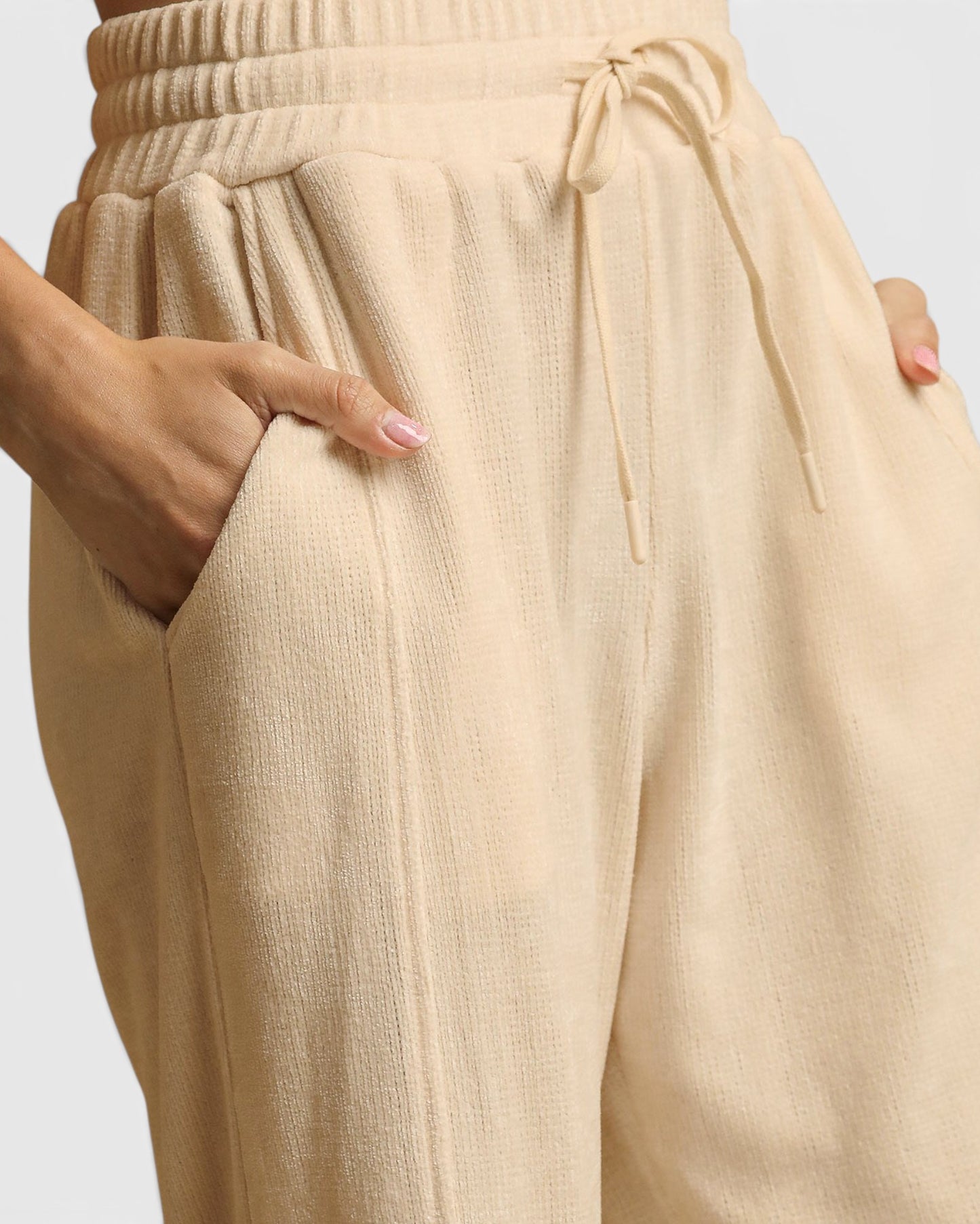 Beige pants with a drawstring waist on a light gray background
